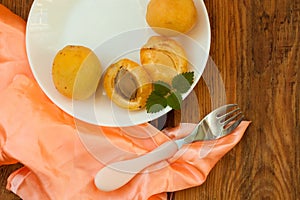 Ripe fresh apricot fruits on a white plate on the wooden background. Copy space, delisious healthy food