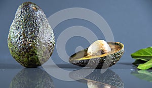 Ripe and fresh avocado fruits Persea americana on dark background