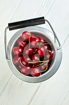 Ripe fresh cherries in aluminium bucket.