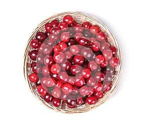 Ripe fresh cherries in a basket on a white isolated background. top view