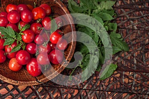 Ripe fresh cherry tomatoes in wooden bowl. Top view, flat lay