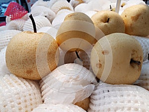 Ripe and Fresh Chinesse Pear in Supermarket Surrounding By Foam Net photo