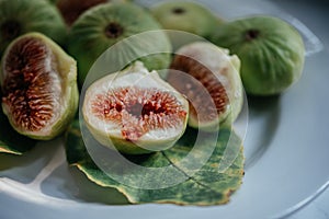 Ripe fresh fig fruits and leaf on white background