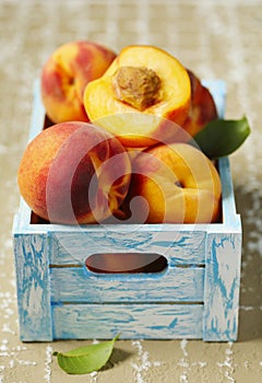 Ripe peaches in wooden box