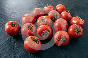 Ripe fresh red organic tomatoes being wet and clean, isolated over black background. Detailed close up shot. Selective focus