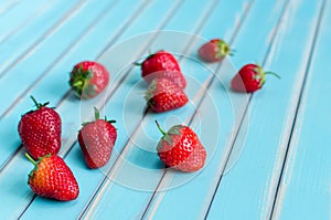 Ripe fresh strawberries over wooden turquoise table background