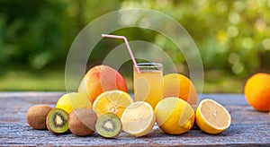 Ripe fruits and a glass of juice on a wooden table