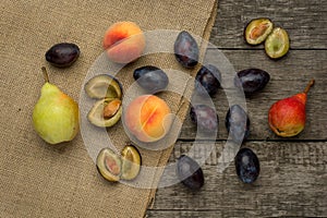 Ripe fruits of peach, plums and pear on rustic