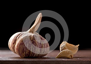 Ripe garlic head with a couple of peeled cloves