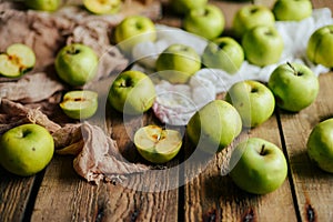 Ripe green apples and apple slices on wooden gray background, to