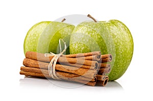 Ripe green apples with cinnamon sticks isolated