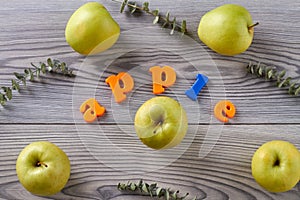 Ripe green apples on wooden grey table.