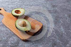 Ripe green avocado on a wooden cutting board serving