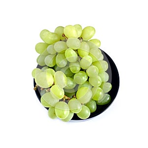 Ripe green grape berries in black round bowl top view