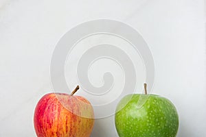 Ripe Green Red Organic Apples on White Marble Background. Lower Border. Creative Minimalist Image for Culinary Vegan Website