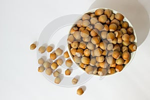 Ripe hazelnuts in a peel on a white background