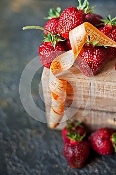 Ripe juicy beautiful red strawberry on a wooden background closeup