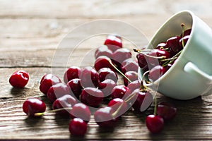 Ripe juicy cherries in Cup on wooden background