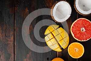 Ripe juicy fresh tropical fruits, on old dark  wooden table background, top view flat lay, with copy space for text