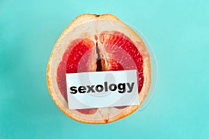 ripe juicy grapefruit with note sexology isolated on a blue background