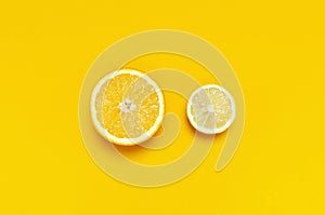 Ripe juicy lemons, orange on bright yellow background. Lemon fruit, citrus minimal concept, vitamin C. Creative summer