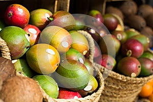 Ripe juicy mango in wicker baskets on market counter