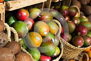 Ripe juicy mango in wicker baskets on market counter