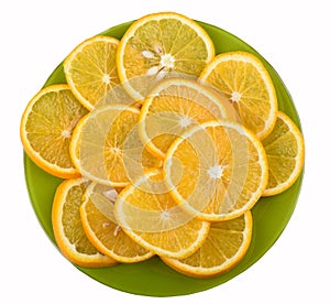 Ripe juicy oranges slices on a green plate isolated on a white background