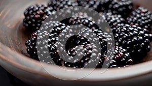 Ripe juicy organic cultivated blackberries in a rustic wooden bowl. Close up.