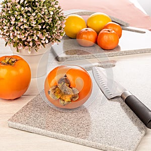 Ripe, juicy persimmon on a cutting board made of artificial stone