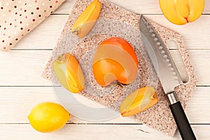 Ripe, juicy persimmon on a cutting board made of artificial stone