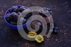 Ripe juicy plums in a bowl on a table