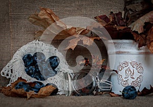 Ripe juicy plums on a rustic autumn vintage background.