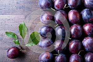 Ripe juicy plums on a wooden background