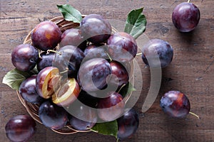 Ripe juicy plums on a wooden background.