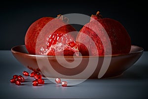 Ripe juicy pomegranates lie on a clay dish