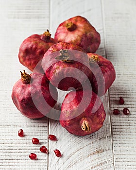 Ripe juicy pomegranates on a white wooden background. Fruit harvesting