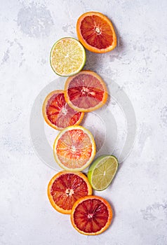 Ripe juicy slices of red oranges spread out on a white background