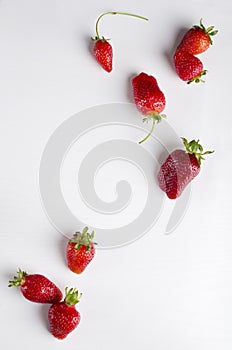 Vertical image.Topv iew of set of fresh delicious strawberries on the white surface.Empty space, board photo