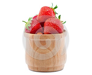 Ripe, juicy strawberries imposed in a wooden bowl.
