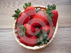 Ripe juicy strawberries in a wicker basket.