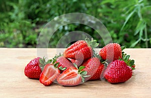 Ripe juicy strawberry  garden strawberry, Fragaria x ananassa  on wooden table in garden