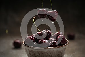 Ripe juicy sweet cherries with water drops in a ceramic bowl