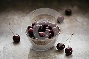 Ripe juicy sweet cherries with water drops in a ceramic bowl
