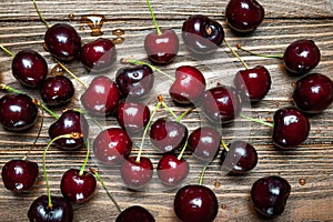 Ripe juicy sweet cherries on a wooden background. Top view wet fresh cherries with water drops