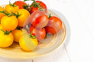Ripe juicy tomatoes on large wooden plate