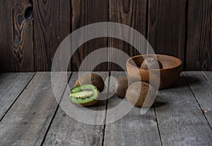 Ripe kiwi on a wooden background in a wooden bowl