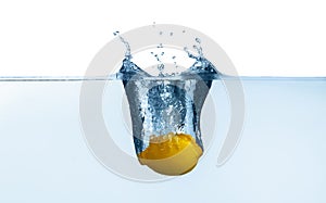 Ripe lemon falling down into clear water with splashes against white background