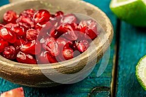 Ripe lime, pomegranate fruit on wooden vintage background. Healthy vegetarian food.