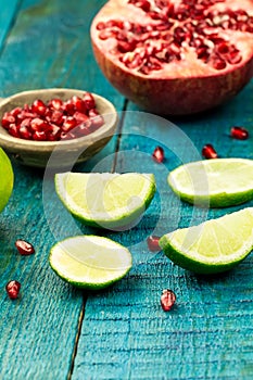 Ripe lime, pomegranate fruit on wooden vintage background. Healthy vegetarian food.